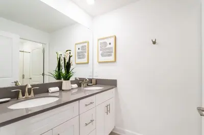 a white bathroom with two sinks and a mirror at Storey Lake Resort 1084 - Hosted by Top Villas in Kissimmee