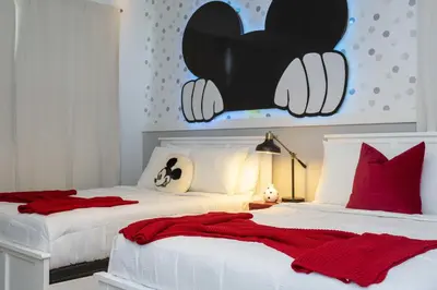 two beds in a bedroom with a mickey mouse head on the wall at Storey Lake Resort 1086 - Hosted by Top Villas in Kissimmee