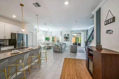 a kitchen and living room with a counter and chairs at Storey Lake Resort 1092 - Hosted by Top Villas in Kissimmee