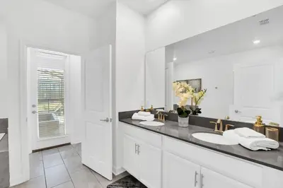 a white bathroom with a sink and a mirror at Storey Lake Resort 1095 - Hosted by Top Villas in Kissimmee