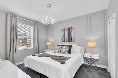 a white bedroom with a large bed and a window at Storey Lake Resort 1095 - Hosted by Top Villas in Kissimmee