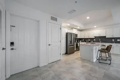 a large kitchen with white cabinets and a chair in it at Storey Lake Resort 1099 - Hosted by Top Villas in Kissimmee
