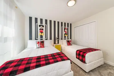 two beds in a white room with black and white stripes at Storey Lake Resort 1107 - Hosted by Top Villas in Kissimmee