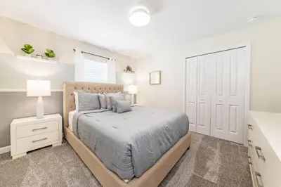 a bedroom with a large bed and a white door at Storey Lake Resort 1113 - Hosted by Top Villas in Kissimmee