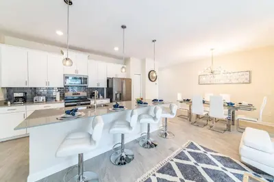 a kitchen with white cabinets and a table and chairs at Last Minute Disney Getaway Townhouse with Private Pool. Book Now 27412 in Kissimmee