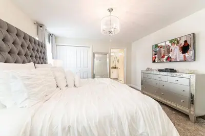 a white bedroom with a large bed and a tv at Last Minute Disney Getaway Townhouse with Private Pool. Book Now 27412 in Kissimmee