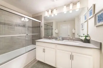 a bathroom with two sinks and a shower at Last Minute Disney Getaway Townhouse with Private Pool. Book Now 27412 in Kissimmee
