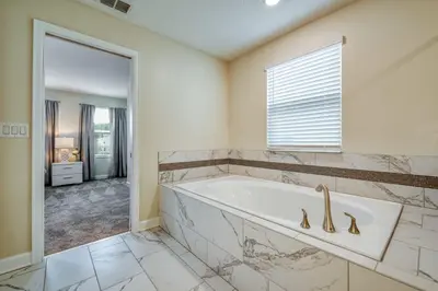 a large bathroom with a tub and a window at Last Minute Disney Private Pool Hot Tub Game Room Themed Bedrooms. Book Now 32850 in Kissimmee