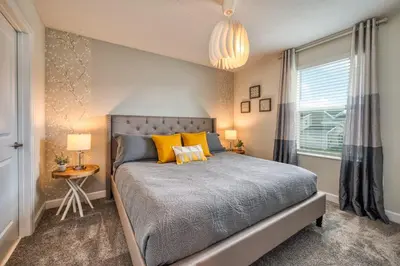 a bedroom with a bed with yellow pillows and a window at Last Minute Disney Private Pool Hot Tub Game Room Themed Bedrooms. Book Now 32850 in Kissimmee