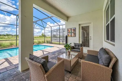 a patio with a table and chairs and a pool at Last Minute Disney Private Pool Hot Tub Game Room Themed Bedrooms. Book Now 32850 in Kissimmee