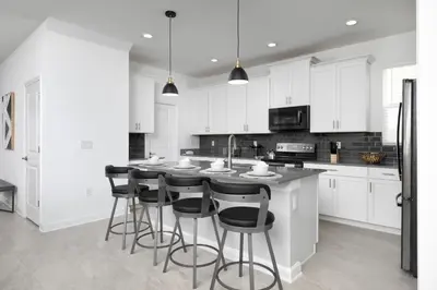 a kitchen with white cabinets and a island with bar stools at Last Minute Disney Private Pool Hot Tub Themed Bedrooms. Book Now 56873 in Kissimmee