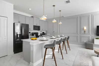 a kitchen with white cabinets and a island with bar stools at Last Minute Disney Getaway Private Pool Themed Bedrooms. Book Now 58079 in Kissimmee