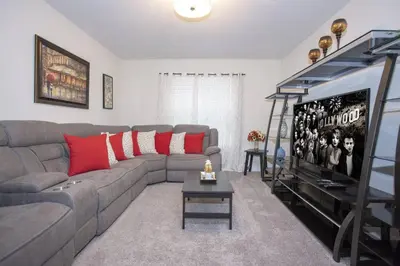 a living room with a gray couch and red pillows at Last Minute Disney Getaway Villa with Private Pool Hot Tub. Book Now 22454 in Kissimmee