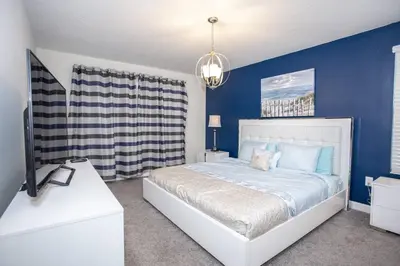 a bedroom with a bed with blue walls and a tv at Last Minute Disney Getaway Villa with Private Pool Hot Tub. Book Now 22454 in Kissimmee