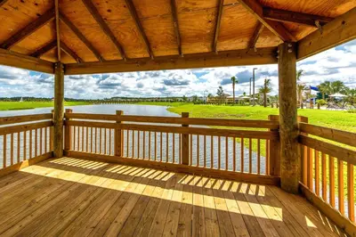 a wooden porch with a view of a lake at Last Minute Disney Getaway Townhouse with Private Pool. Book Now 17402 in Kissimmee