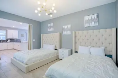 a bedroom with two beds and a chandelier at Storey Lake Resort 972 - Hosted by Top Villas in Kissimmee