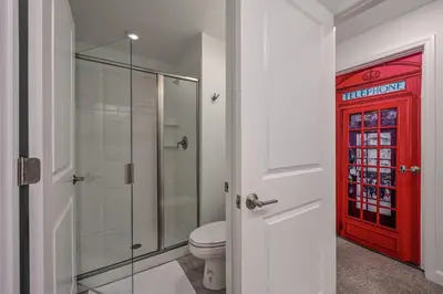 a bathroom with a toilet and a red door at Last Minute Disney Getaway Private Pool Themed Bedrooms. Book Now 91409 in Kissimmee
