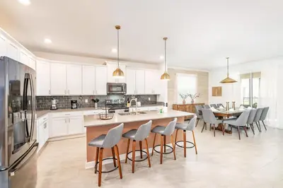 a kitchen with white cabinets and a table and chairs at Last Minute Disney Getaway Villa with Private Pool Hot Tub. Book Now 81933 in Kissimmee