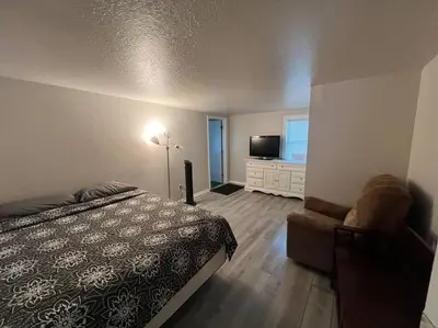 a bedroom with a bed and a chair and a television at Home in Kissimmee with Huge Backyard in Kissimmee