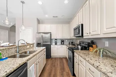 a kitchen with white cabinets and a stainless steel refrigerator at Veranda Palms 8 Bedroom Home with Pool2208 in Kissimmee