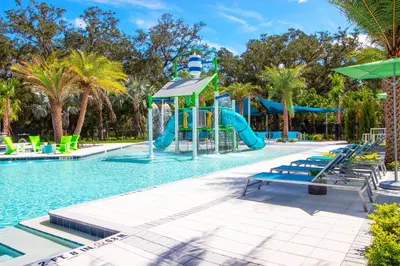 a pool with a slide in a resort with palm trees at Veranda Palms 8 Bedroom Home with Pool2208 in Kissimmee