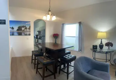 a living room with a dining room table and a chair at Comfortable House with hot tub close to Disney in Kissimmee