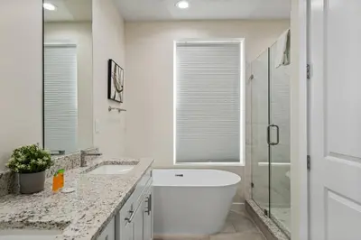 a white bathroom with a tub and a sink at Wonderful towhouse very close to Disney in Orlando