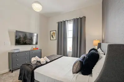 a bedroom with a bed with a dresser and a window at Wonderful towhouse very close to Disney in Orlando