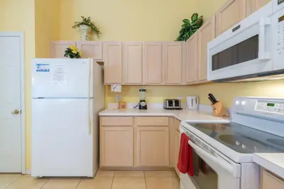 a kitchen with white appliances and a white refrigerator at 4br/3ba Disney Area Luxury Resort with pool/spa in Orlando