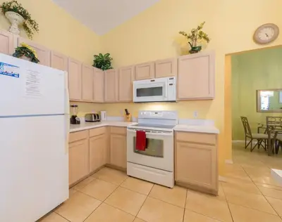 a kitchen with a white refrigerator and a microwave at 4br/3ba Disney Area Luxury Resort with pool/spa in Orlando