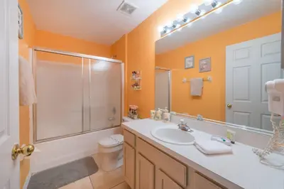a bathroom with a toilet and a sink and a shower at 4br/3ba Disney Area Luxury Resort with pool/spa in Orlando