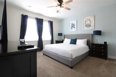 a bedroom with a bed and a ceiling fan at Family Themed House Close to Disney with Private Pool and Huge Backyard in Orlando