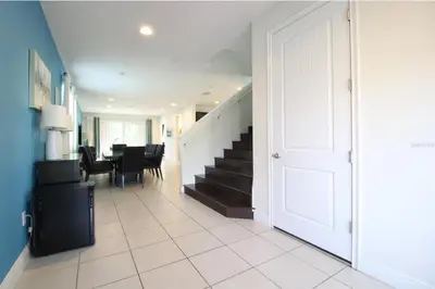 a hallway with a staircase leading to a dining room at Family Themed House Close to Disney with Private Pool and Huge Backyard in Orlando