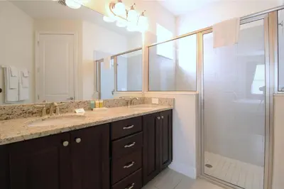 a bathroom with a double sink and a shower at Family Themed House Close to Disney with Private Pool and Huge Backyard in Orlando
