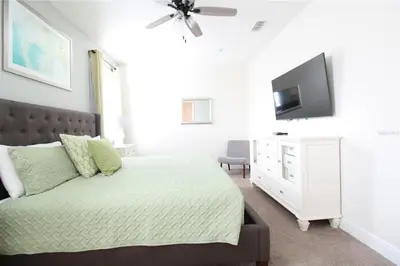 a bedroom with a bed and a flat screen tv at Family Themed House Close to Disney with Private Pool and Huge Backyard in Orlando