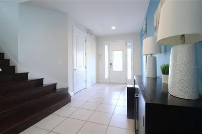 a hallway with a staircase in a home with blue walls at Family Themed House Close to Disney with Private Pool and Huge Backyard in Orlando