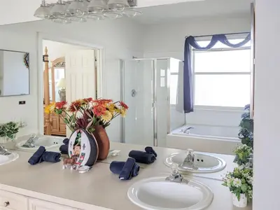 a bathroom with two sinks and a vase with flowers at 5 Bed 8002 in Kissimmee