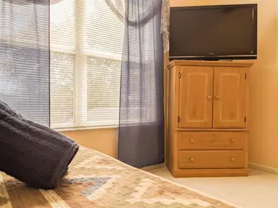a tv on top of a dresser in a bedroom at 5 Bed 8002 in Kissimmee