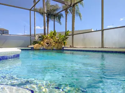 a swimming pool with blue water and palm trees at 5 Bed 8002 in Kissimmee