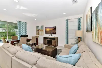 a living room with a couch and a table at Charming Home With Themed Rooms, Game Room And Waterpark & Resort Access Near Disney At Encore Resorts Reunion - 300Pn in Kissimmee