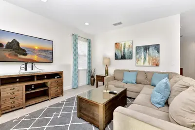 a living room with a couch and a tv at Charming Home With Themed Rooms, Game Room And Waterpark & Resort Access Near Disney At Encore Resorts Reunion - 300Pn in Kissimmee