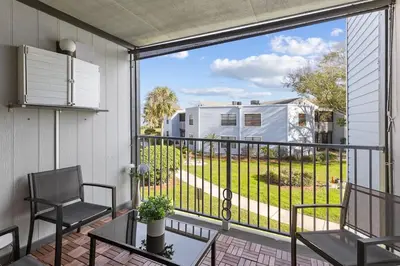 a balcony with a table and chairs and a view of a yard at Disney and Airport 15 minutes from Luxury Condo in Orlando