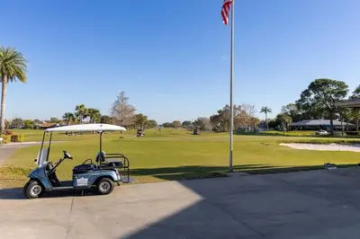 a golf cart parked next to a golf course at Disney and Airport 15 minutes from Luxury Condo in Orlando