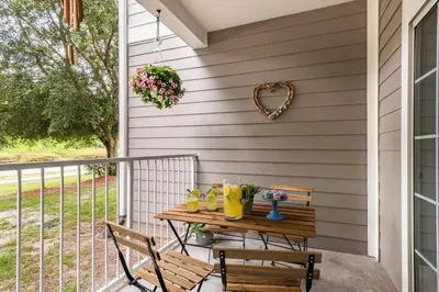 a table on a porch with two chairs and a heart wreath at Newly Renovated First Floor 3Bed & 2 Bath, OUTDOOR POOL, 10-min to Disneyworld & Animal Kingdom! in Kissimmee