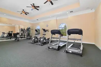 a gym with several treadmills and exercise bikes at Newly Renovated First Floor 3Bed & 2 Bath, OUTDOOR POOL, 10-min to Disneyworld & Animal Kingdom! in Kissimmee
