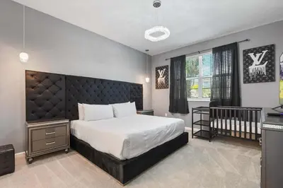 a bedroom with a large bed and a crib at Family-Friendly Luxury Home Near Disney & More in Kissimmee