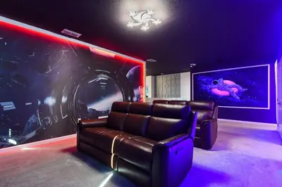 a cinema room with a couch and a machine at Family-Friendly Luxury Home Near Disney & More in Kissimmee