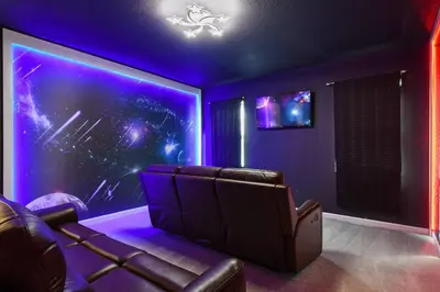 a room with a couch and a stage with purple lights at Family-Friendly Luxury Home Near Disney & More in Kissimmee