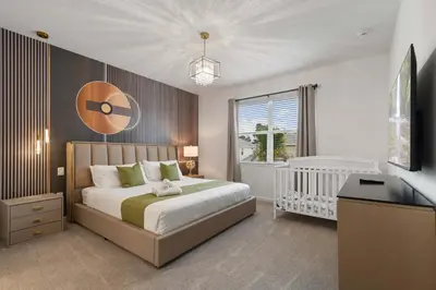 a bedroom with a large bed and a baby crib at Spacious 12BR Disney Themed Home Pool/SPA/BBQ/Game in Kissimmee