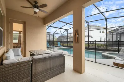 a living room with a view of a pool at NEW Disney Themed 12BR Home Pool/SPA/Game/Tiki Bar in Kissimmee